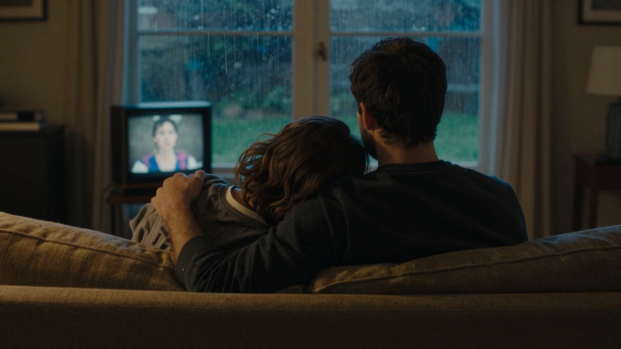 Un homme et une femme silencieux sur un canapé, elle appuyée contre lui, la pluie coulant sur la fenêtre derrière eux.