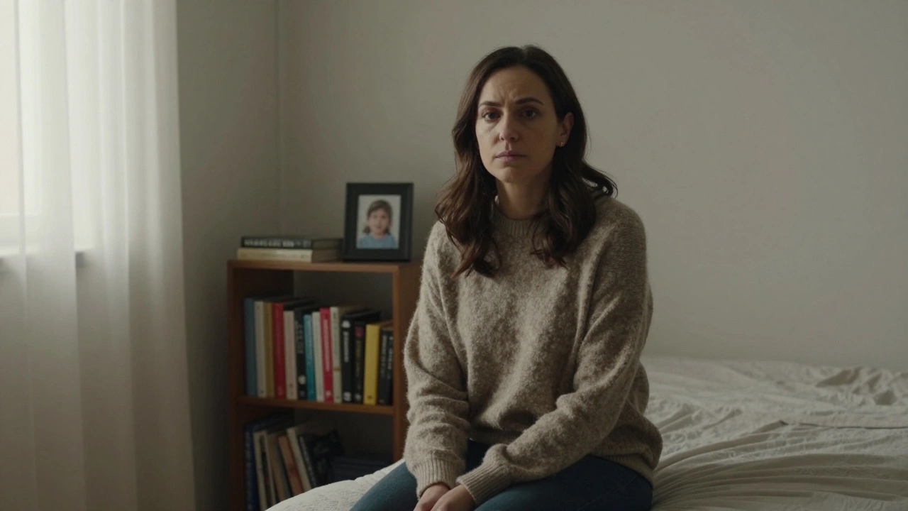 Une femme regardant l'objectif, assise sur un lit, vêtue d'un pull, dans une chambre simple et authentique.