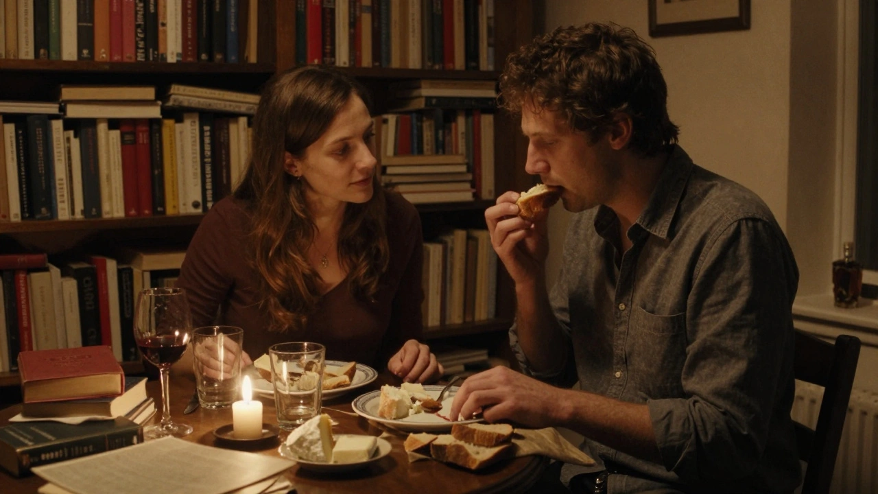 Une femme pose sa main sur la cuisse de l'homme tandis qu'il mord un morceau de fromage déposé sur son doigt.